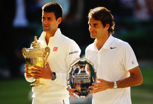 LONDON, ENGLAND - JULY 06:  Novak Djokovic of Serbia poses with the Gentlemen's Singles Trophy next to Roger Federer of Switzerland following his victory in the Gentlemen's Singles Final match on day thirteen of the Wimbledon Lawn Tennis Championships at the All England Lawn Tennis and Croquet Club on July 6, 2014 in London, England.  (Photo by Al Bello/Getty Images)