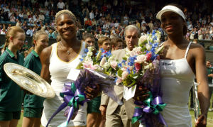 WIMBLEDON, UNITED KINGDOM:  US Serena Williams (L) and her sister Venus hold their trophy's after the Women's final at the Wimbledon Tennis Championships, 06 July 2002. Serena won 7-6 and 6-3. It is the first time in 118 years that sisters have met in the final at Wimbledon.  AFP PHOTO   GERRY PENNY (Photo credit should read GERRY PENNY/AFP/Getty Images)