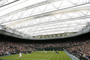 English tennis player Tim Henman (L) and Dutch tennis player Kim Clijsters (R) play in a mixed doubles match on centre court against American tennis player Andre Agassi and German tennis player Steffi Graf during the launch of the new retractable roof on centre court at The All England Lawn Tennis Club, England, on May 17, 2009. AFP PHOTO/Glyn Kirk (Photo credit should read GLYN KIRK/AFP/Getty Images)