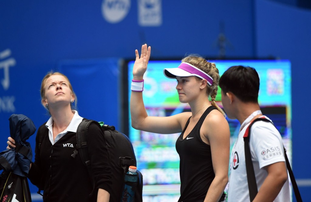 Eugenie Bouchard (C) of Canada waves to the audience after retiring from her first round women's singles match against Andrea Petkovic of Germany at the China Open tennis tournament in Beijing on October 5, 2015.   AFP PHOTO / GOH CHAI HIN        (Photo credit should read GOH CHAI HIN/AFP/Getty Images)