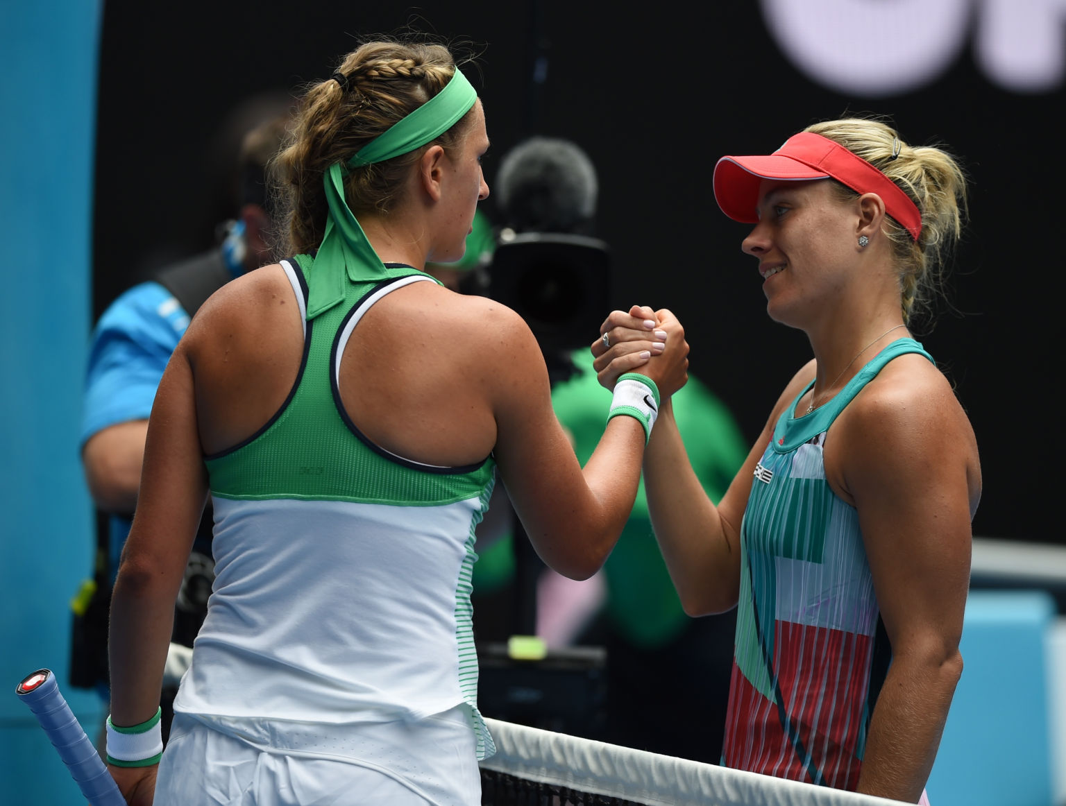 Germany's Angelique Kerber (R) shakes hands as she celebrates after victory in her women's singles match against Belarus's Victoria Azarenka on day ten of the 2016 Australian Open tennis tournament in Melbourne on January 27, 2016. AFP PHOTO / GREG WOOD-- IMAGE RESTRICTED TO EDITORIAL USE - STRICTLY NO COMMERCIAL USE / AFP / GREG WOOD        (Photo credit should read GREG WOOD/AFP/Getty Images)