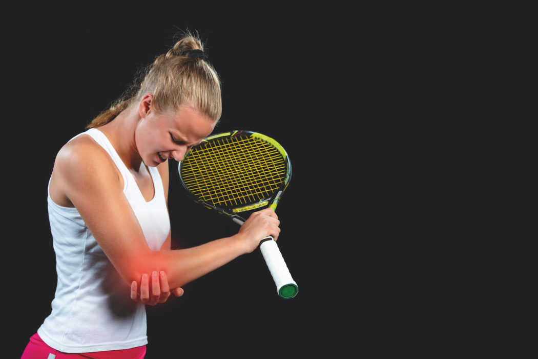tennis woman player with injury holding the racket on a tennis court