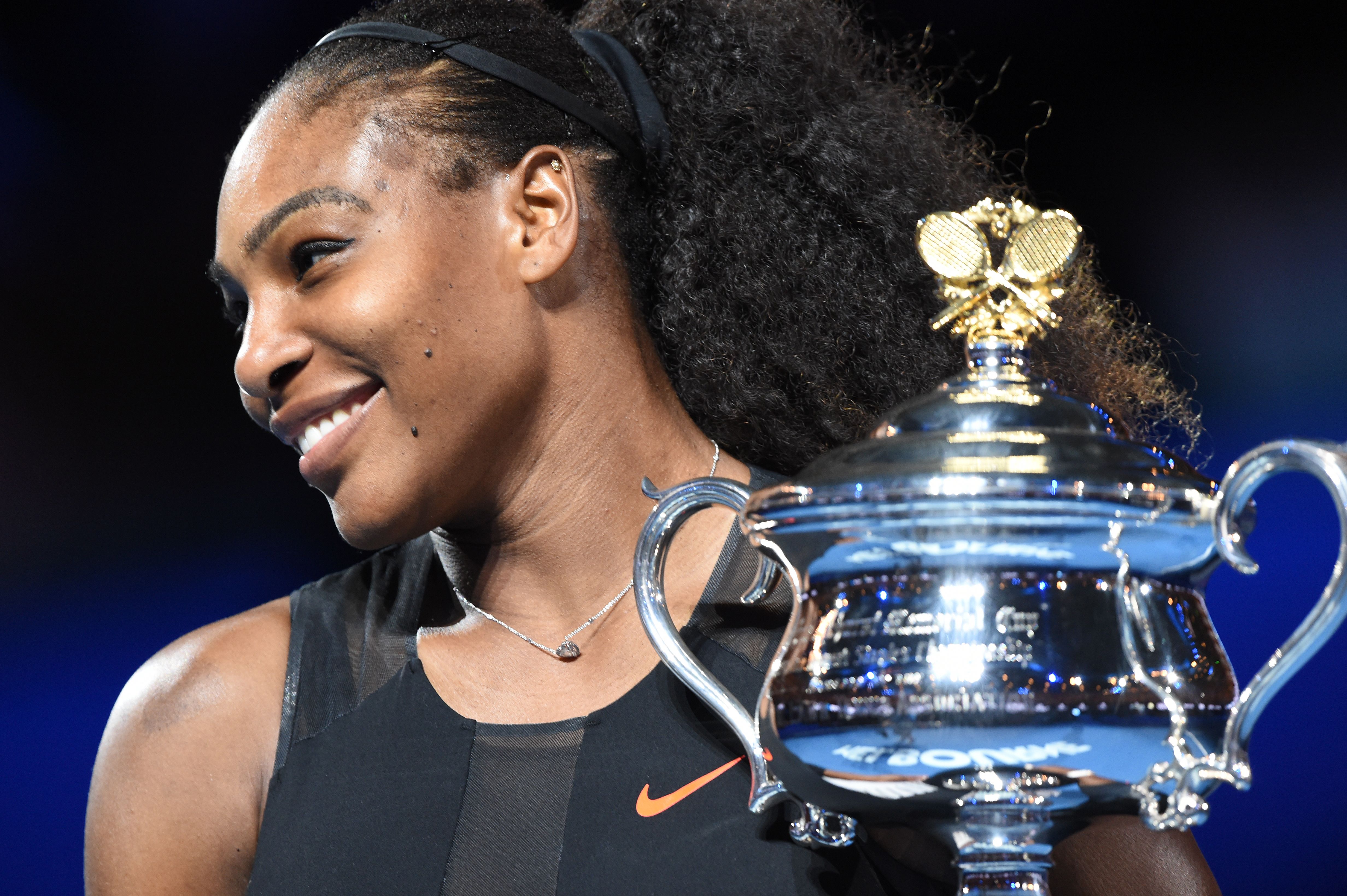 Serena Williams of the US holds up the trophy following her victory over Venus Williams of the US in the women's singles final on day 13 of the Australian Open tennis tournament in Melbourne on January 28, 2017. / AFP / PAUL CROCK / IMAGE RESTRICTED TO EDITORIAL USE - STRICTLY NO COMMERCIAL USE (Photo credit should read PAUL CROCK/AFP/Getty Images)