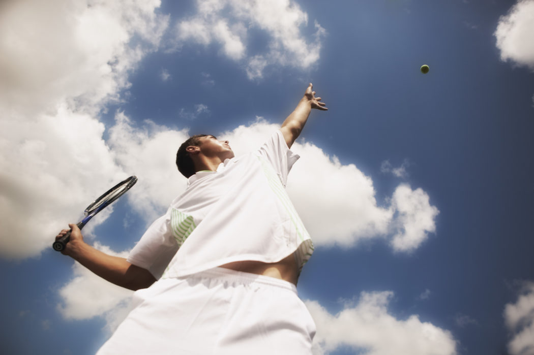 Tennis player serving tennis ball