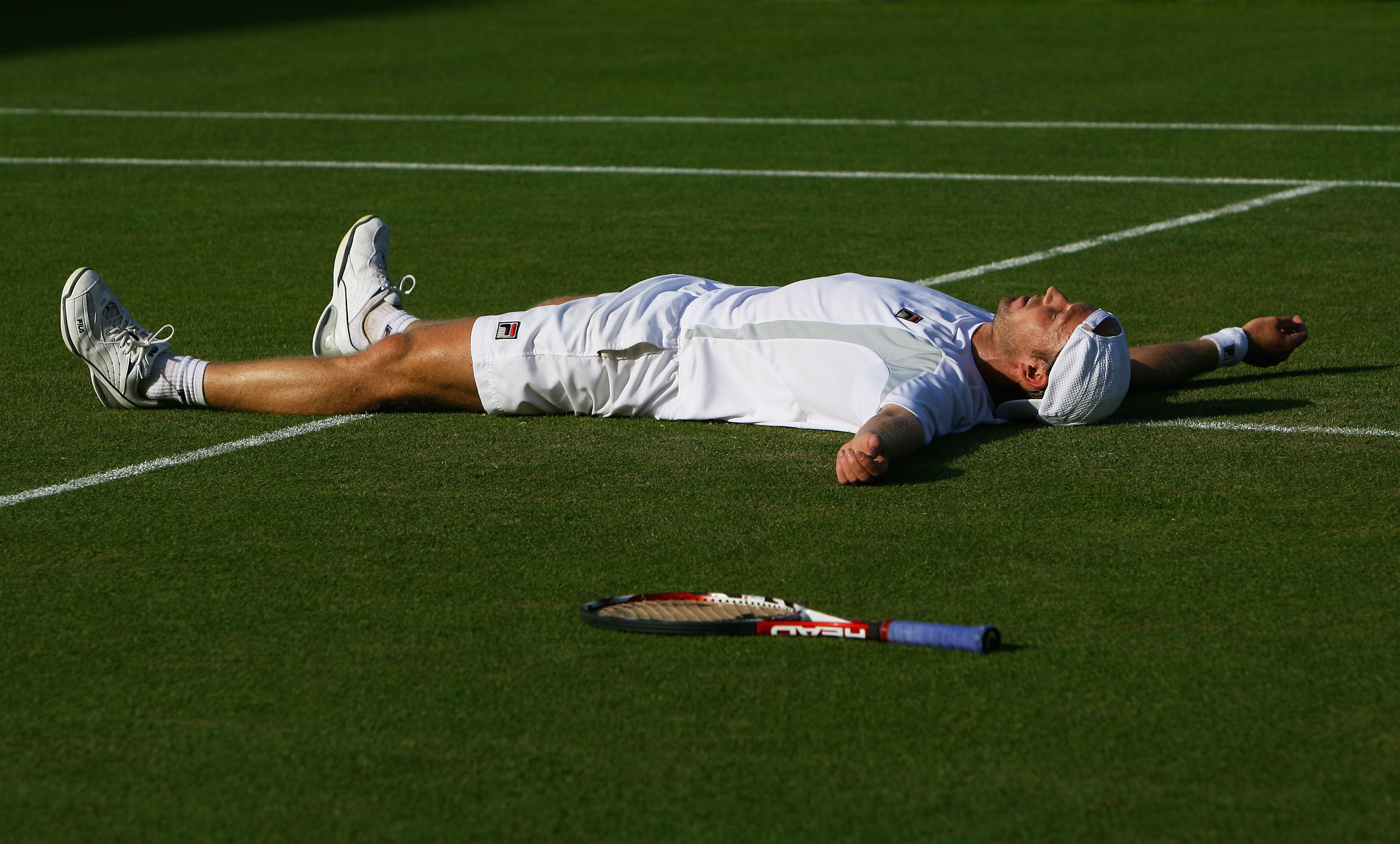 Einziges Aufeinandertreffen: Nach einem hart umkämpften Match gegen Tipsarevic lies Rainer Schüttler sich 2008 auf den Rasen in Wimbledon fallen.