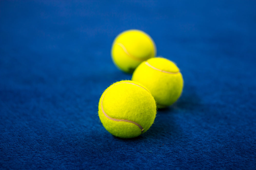 Tennis balls on blue court.